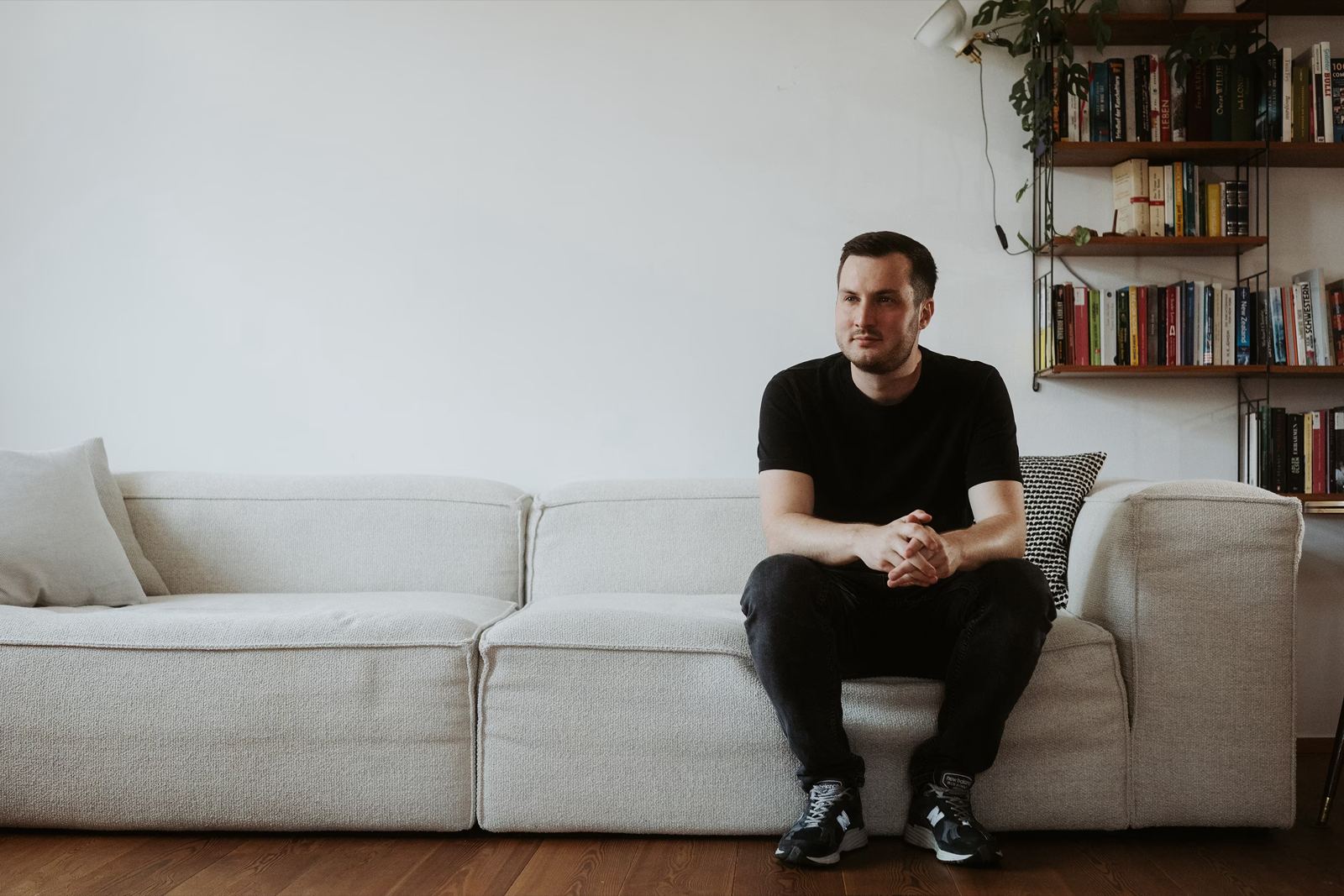 Peter Falkenberg sitzt vor seinem Bücherregal