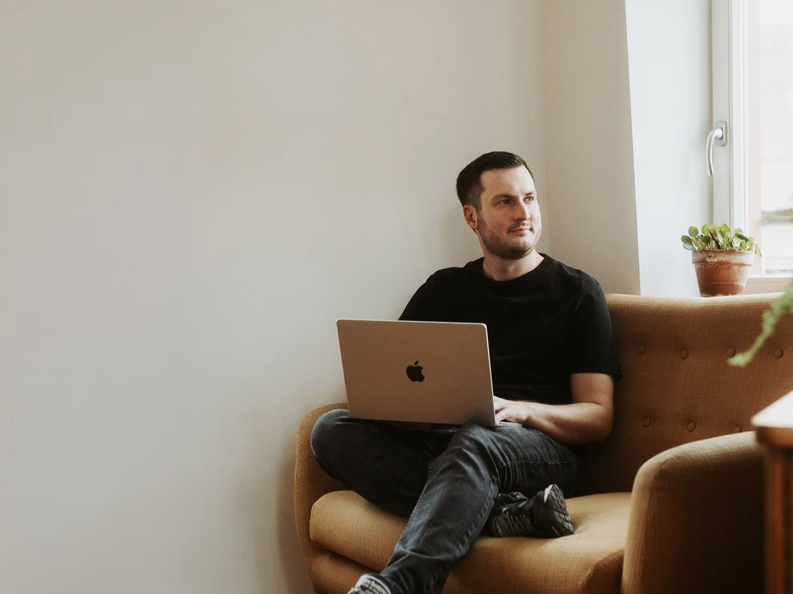 Peter Falkenberg arbeitet mit dem Laptop auf dem Sofa